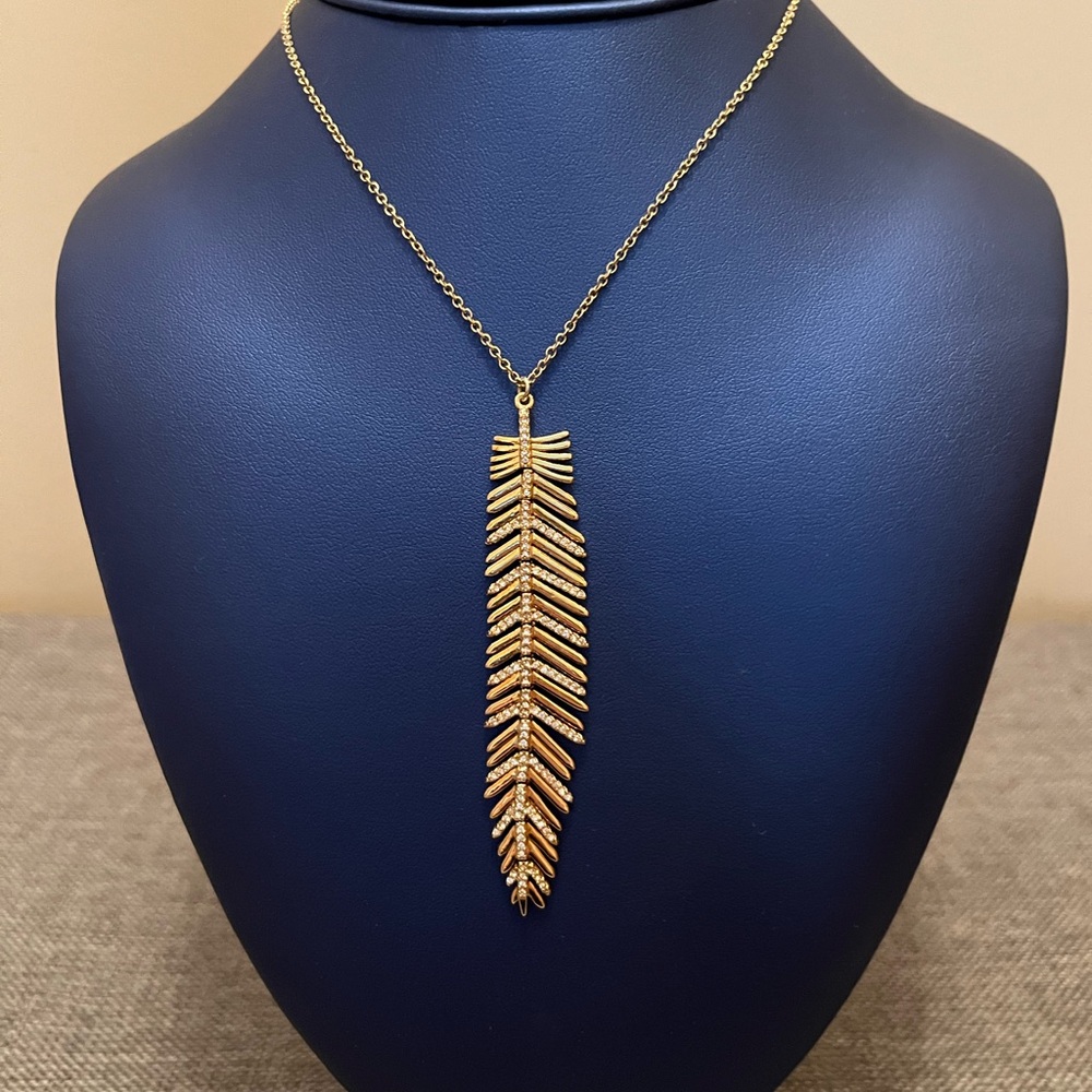 Fancy feather pendent with chain. Swarovski crystals and in gold color.